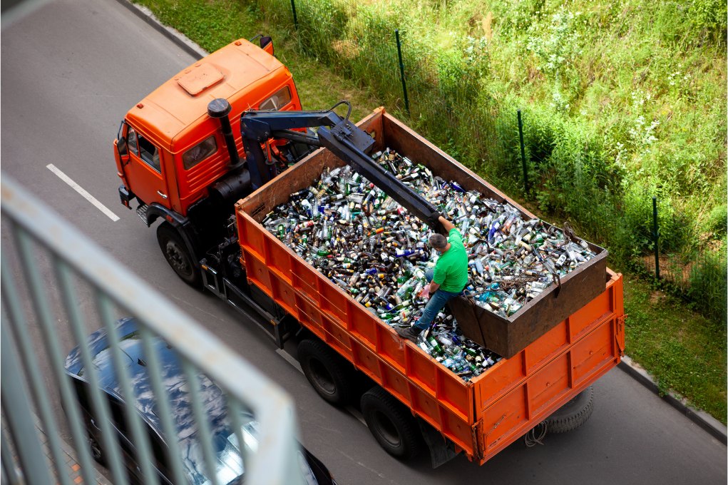 Sammelfahrzeug mit Altglas aus der Vogelperspektive während der Leerung